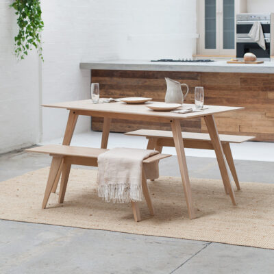 A Scandinavian inspired Brenin Dining Table sits alongside a set of Brenin Benches in a light, open plan kitchen-dining space. Both the table and seats are made in England using high quality Oak veneer on Birch plywood.